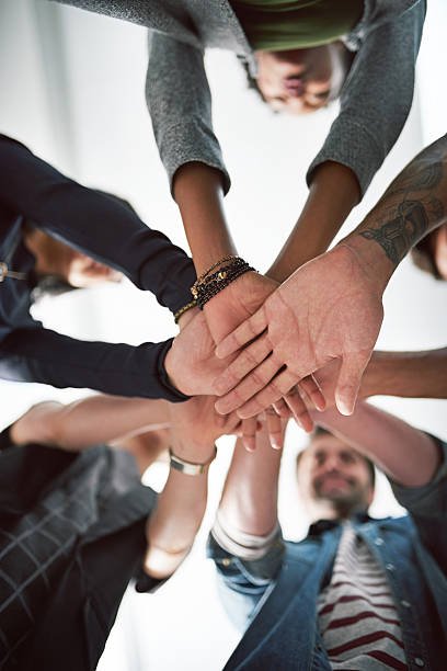Cropped shot of a group of people stacking their hands on top of each other
